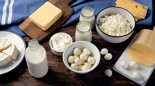 Various lactose products such as milk, eggs and cheese on a wooden table